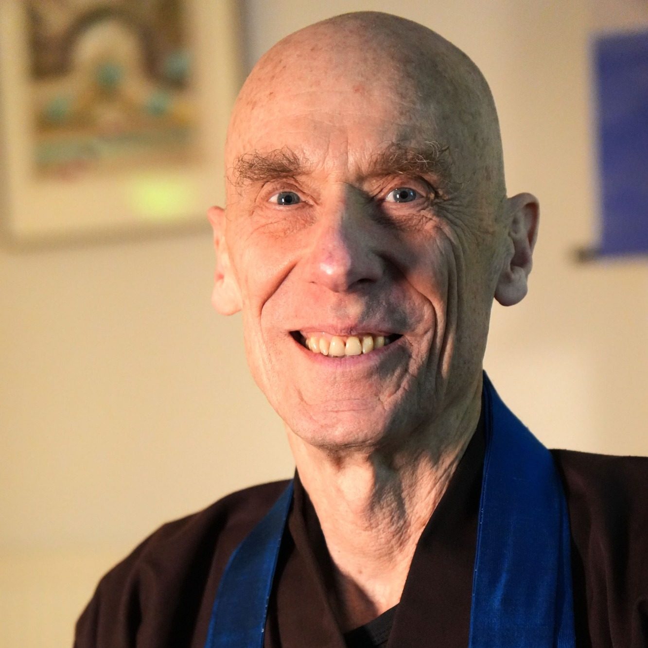 Gerald Weischede lächelt in die Kamera und trägt seine buddhistische Robe.