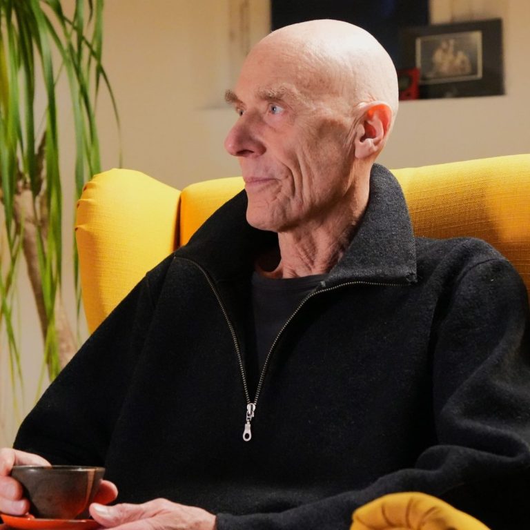 Gerald Weischede sitzt nachdenklich in einem gelben Sessel mit einer Tasse Tee.